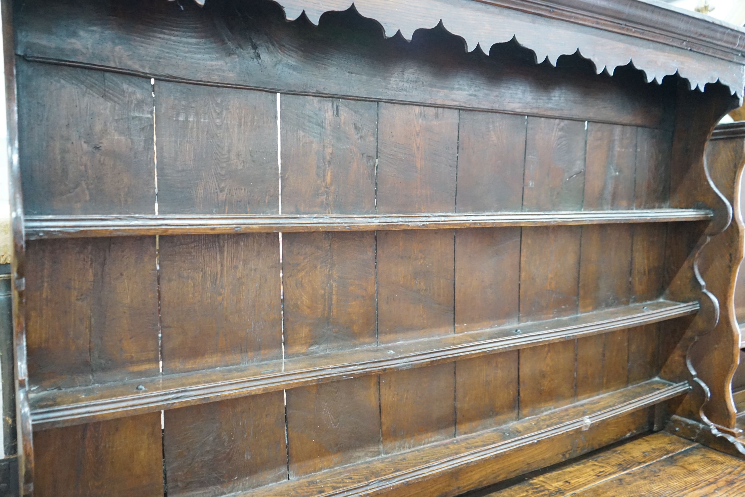 An 18th century oak dresser with boarded rack, length 172cm, depth 50cm, height 198cm